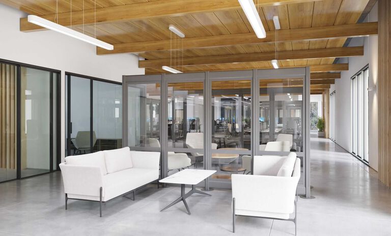 White couches and a coffee table create a comfortable meeting area within the office.