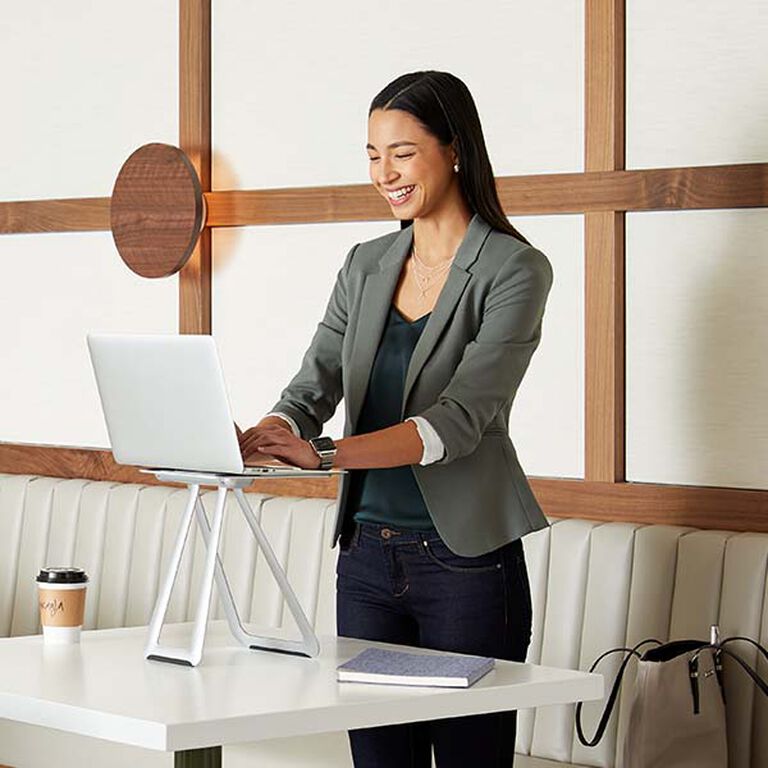 professional standing to work with their laptop elevated with a portable laptop stand