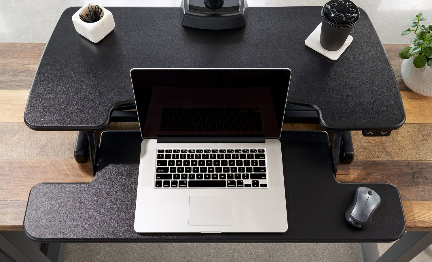 overhead view of a electric standing desk converter with a laptop on top of it