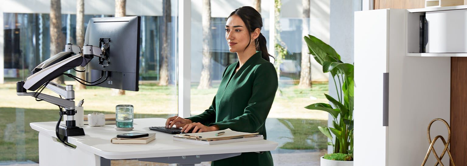 professional working at electric standing desk in office setting