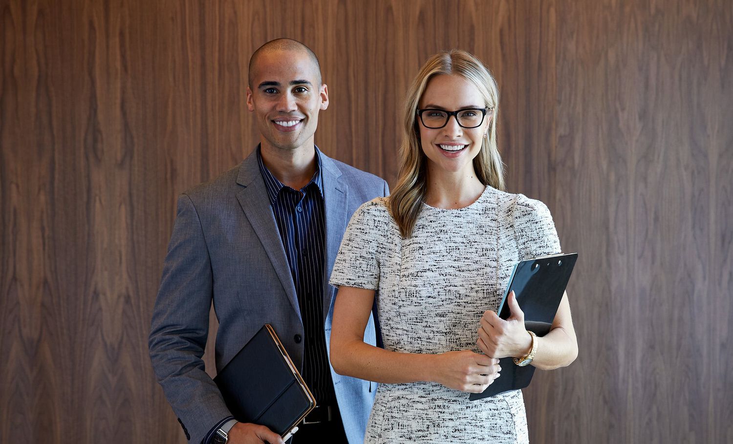 two professionals holding notepads