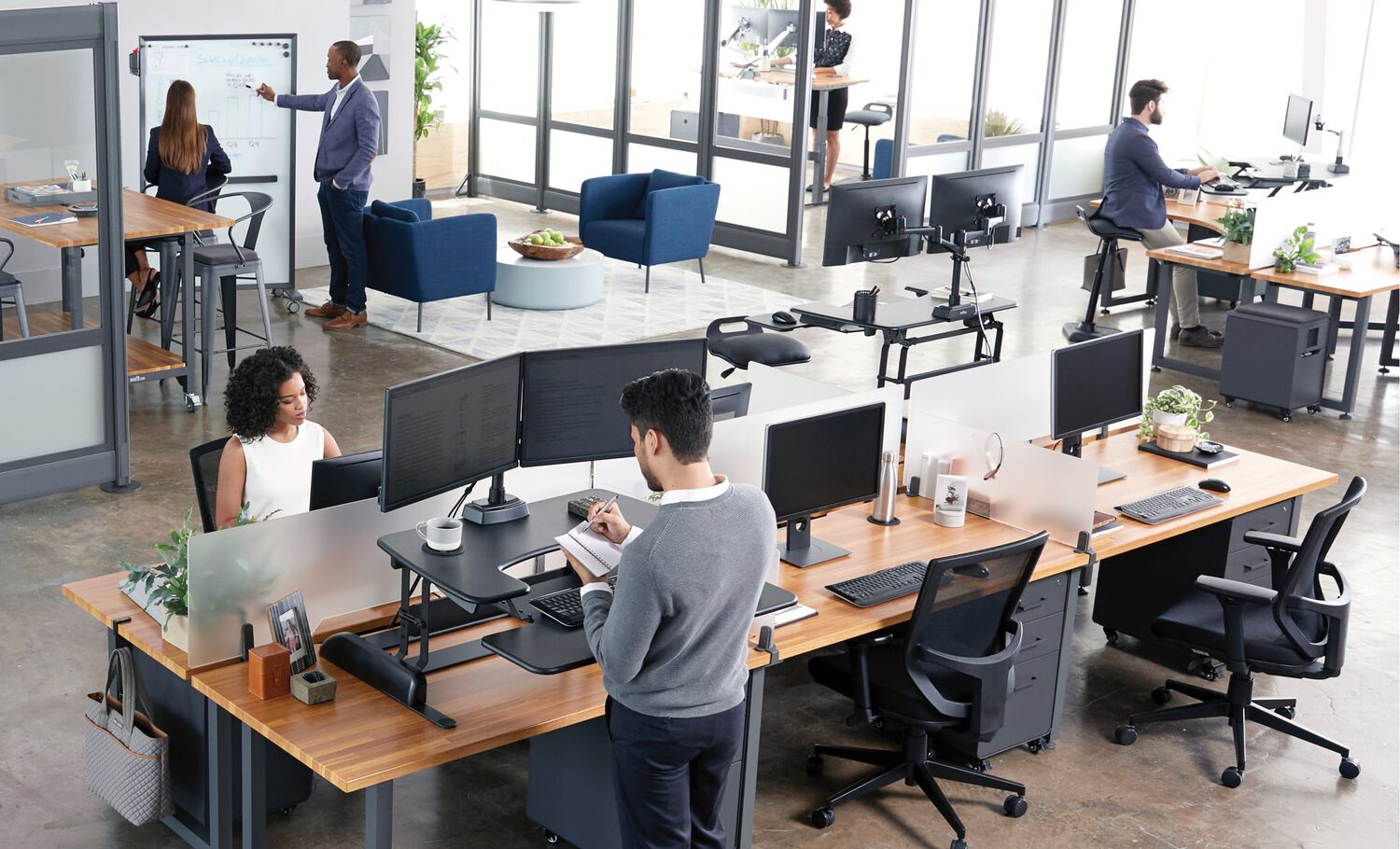 open office with Vari products as seen from above, with employees working in various areas including benched desks, private offices, and conference rooms