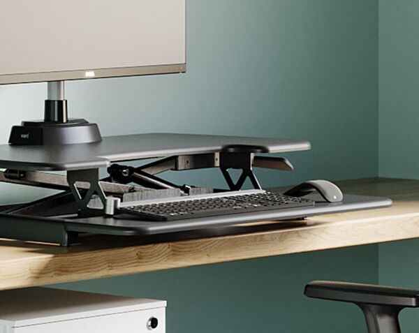 Converter raised on desk in office, keyboard tray holds mouse and keyboard