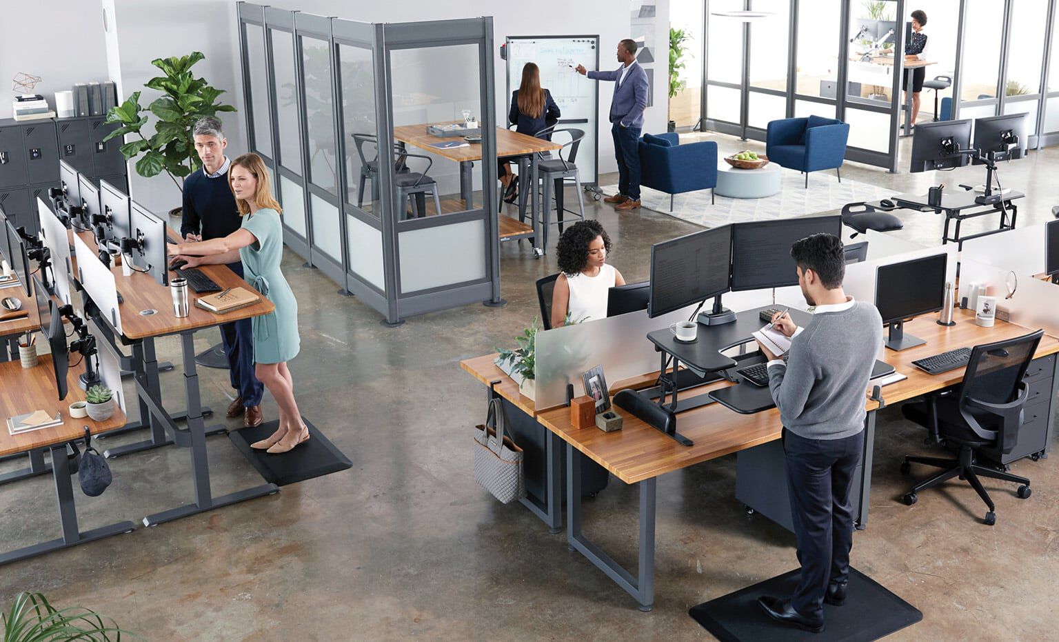 open office with Vari products as seen from above, with employees working in various areas including benched desks, private offices, and conference rooms