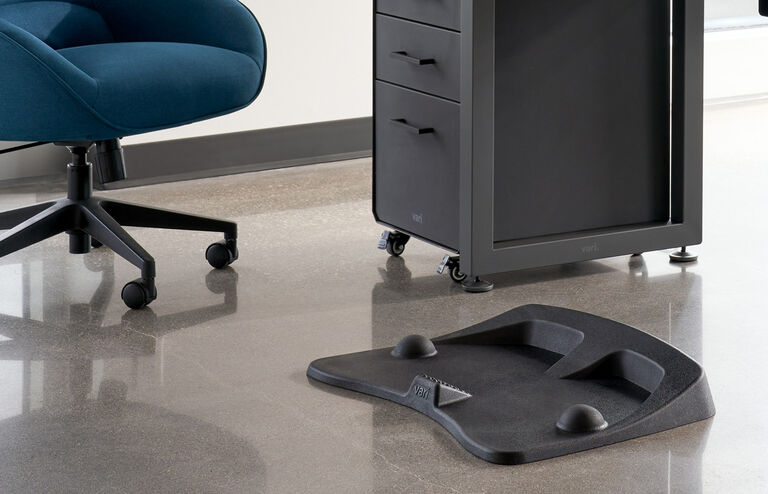 Individual standing on vari active mat in office