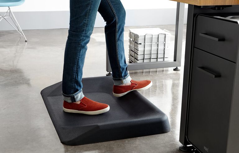 Individual standing on vari active mat in office