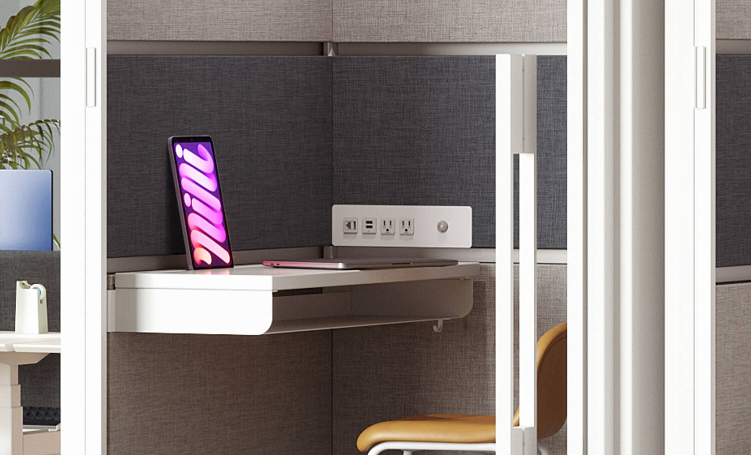 zoomed in view of the adjustable desktop inside of the privacy booth close to the power outlets