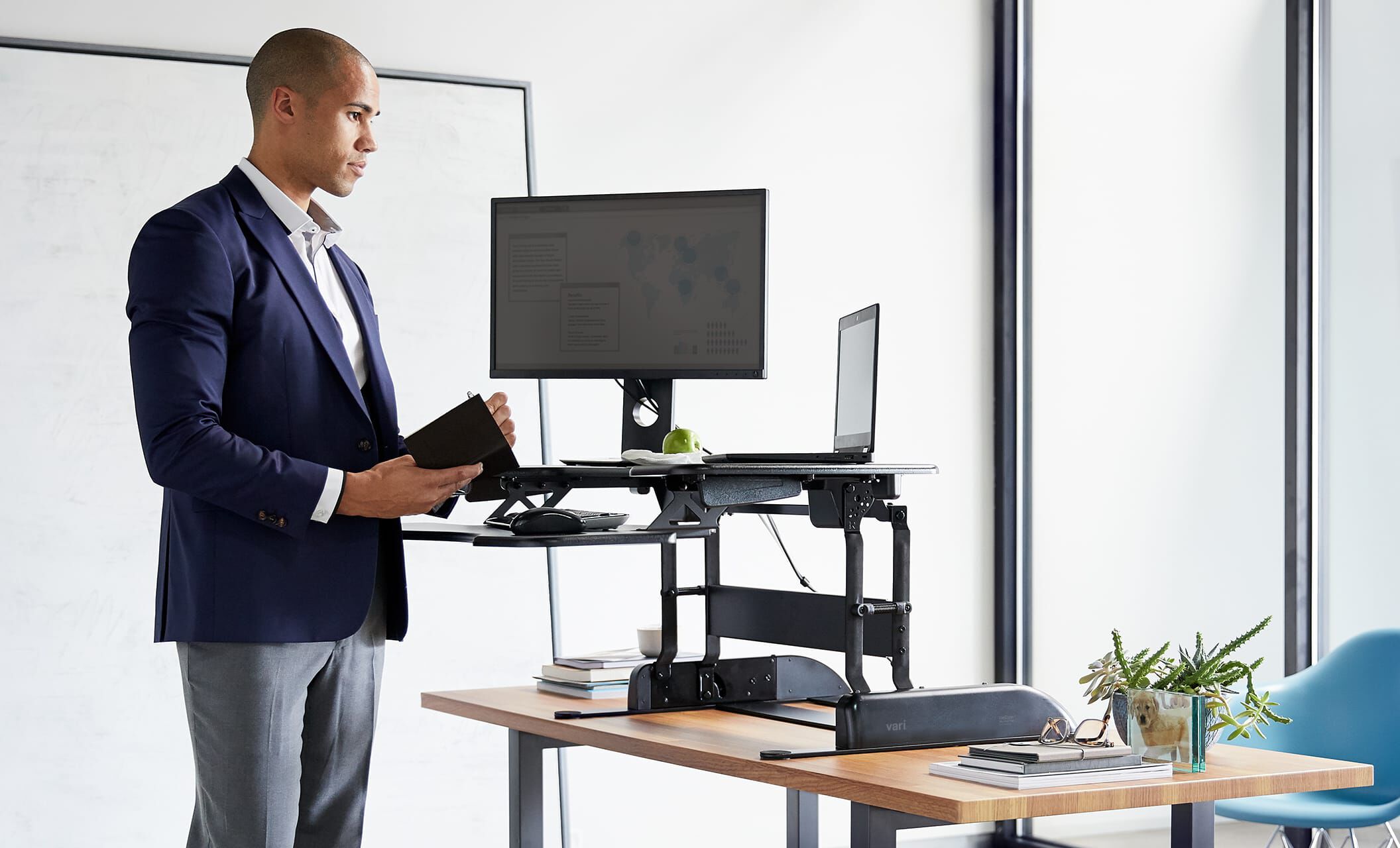 Individual is standing at a raised converter ontop of a desk working in an office setting