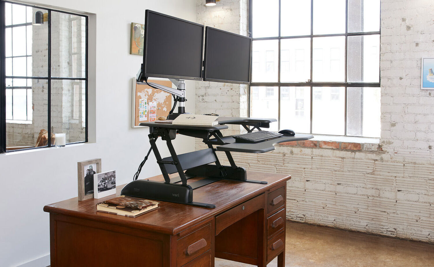 professional woman using varidesk standing desk converter in an office setting
