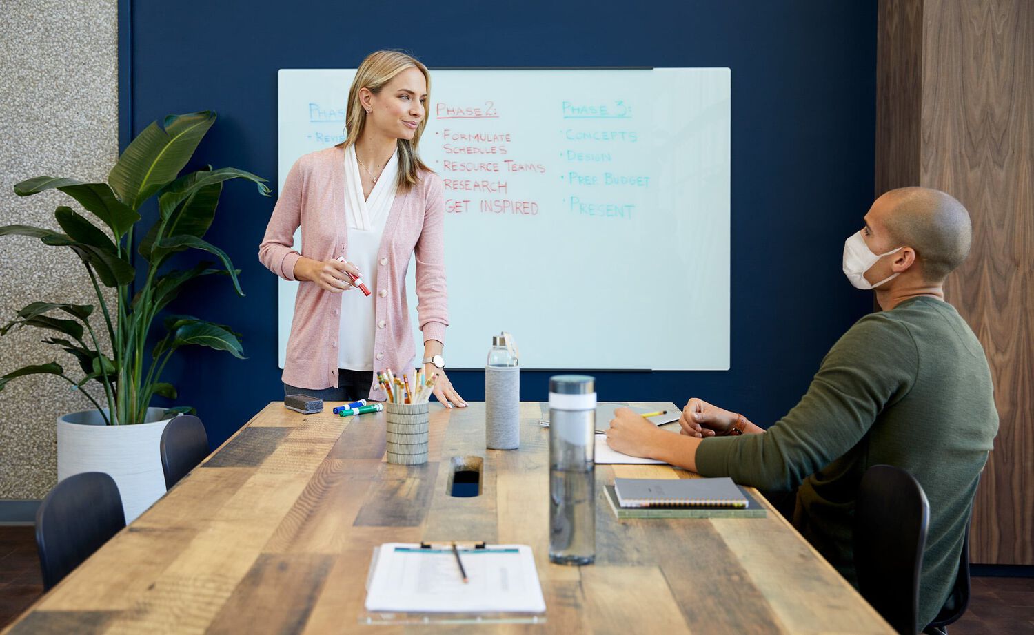 Professional leading meeting at seated conference table