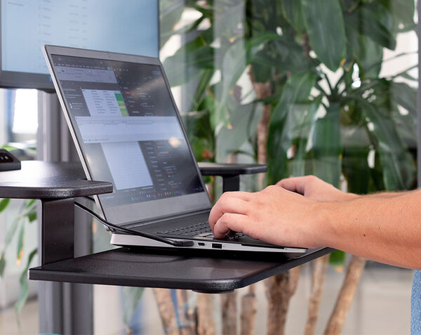 close up view of varidesk premier electric keyboard stand with a keyboard used on the shelf