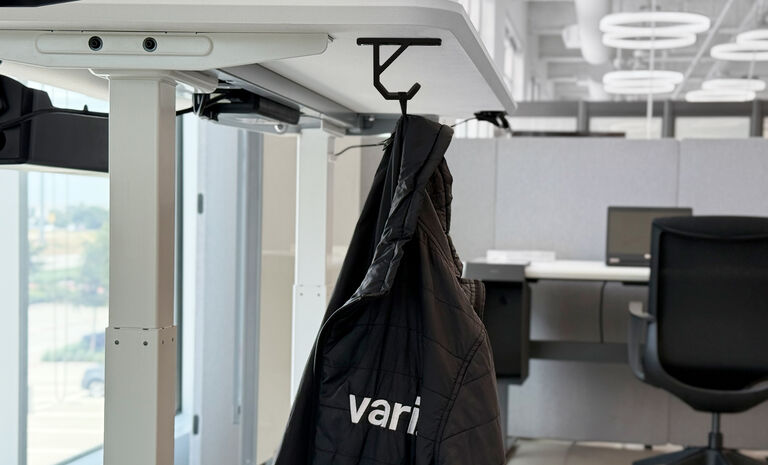 undermount bag hook attached to a desk holding a jacket