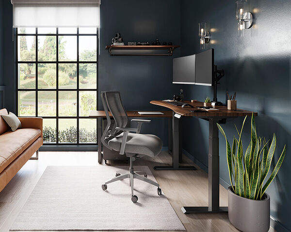a home office with a standing desk, chair and couch