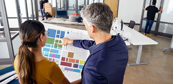 office professionals reviewing a floorplan demonstrating speed from concept to completion