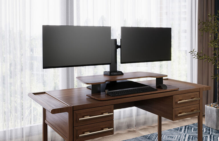 premier electric dual-monitor in a lowered position setup on a desk in a cubicle 