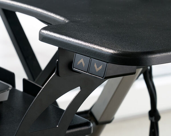 Close-up of the black up and down height adjustment buttons on the side of a desk converter, with the X-frame lift mechanism visible below.