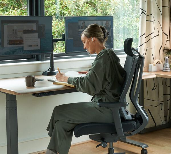 individual working at electric standing desk in a home office setting