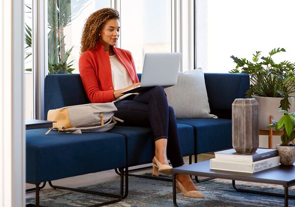 Professional working on laptop in vari soft seating breakout pod