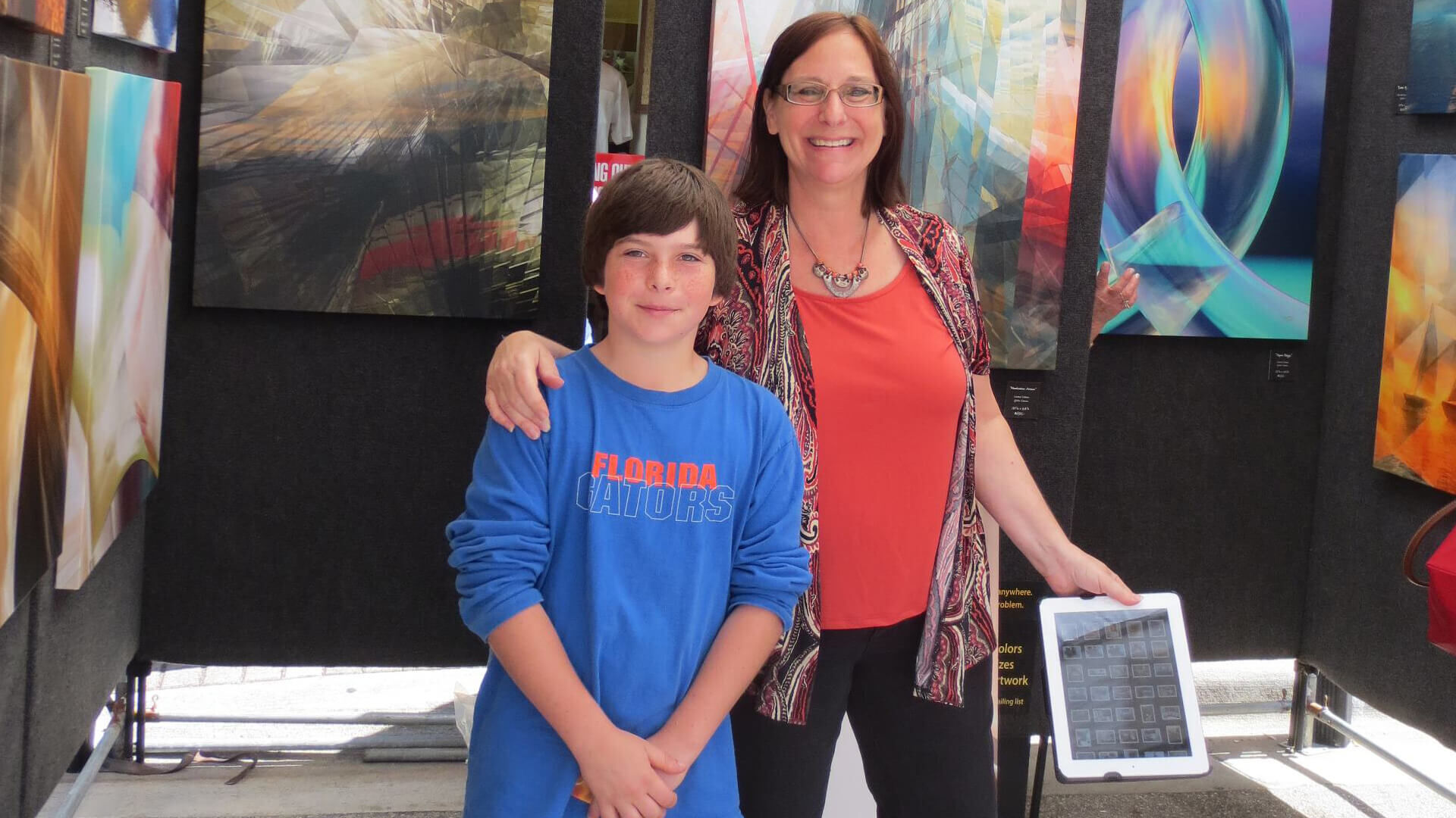 woman and boy standing in front of art