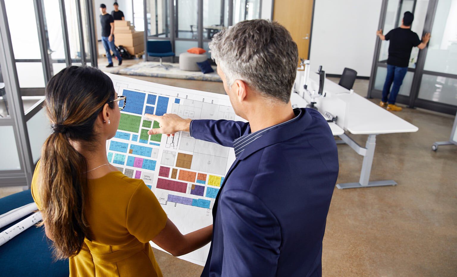 people reviewing a space plan in an office undergoing a furniture design project