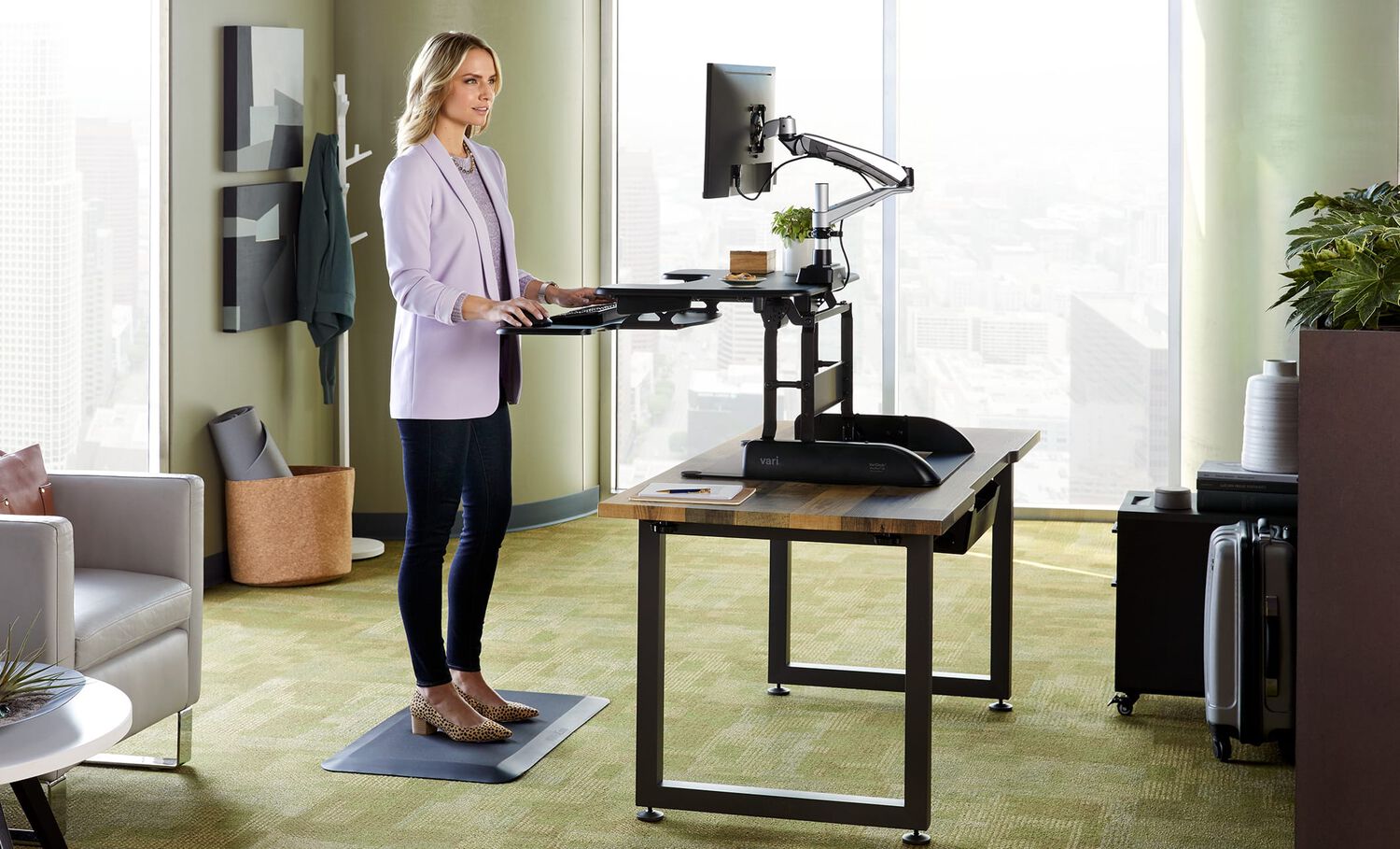 Individual in office using desk converter and vari single monitor arm