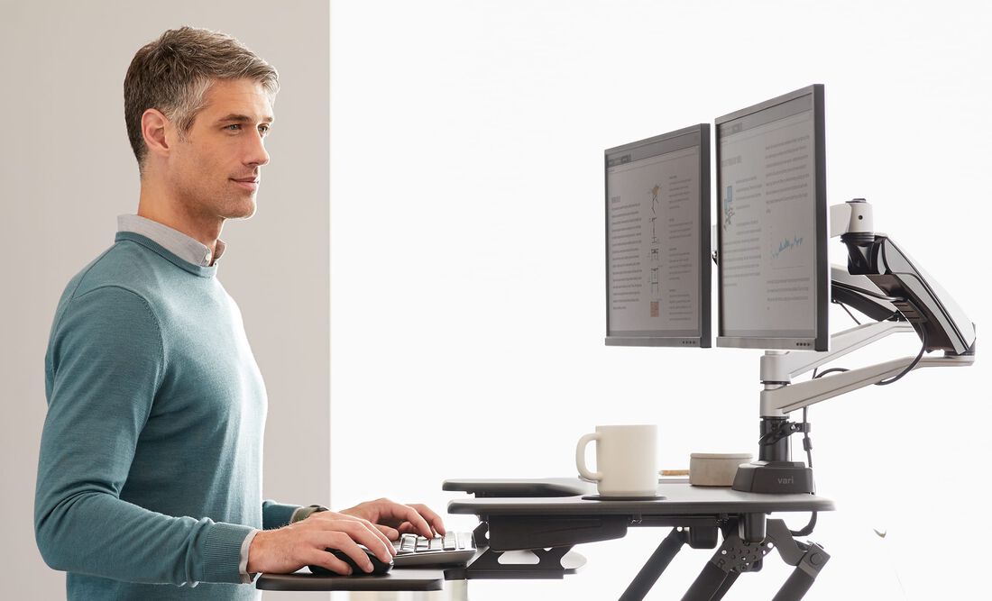 Person working at VariDesk Converter with two monitors