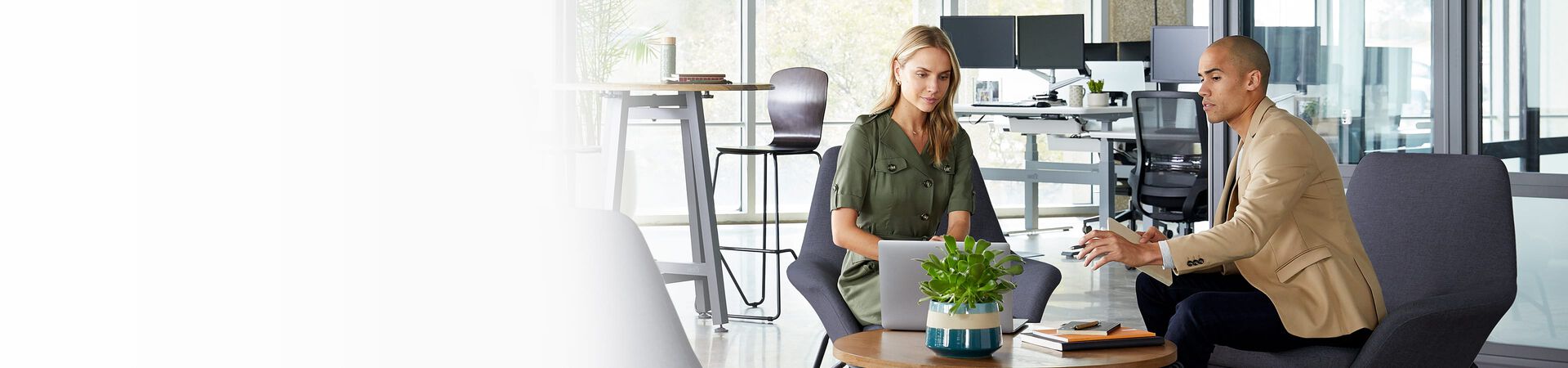 two professionals review presentation while sitting in cushioned chairs