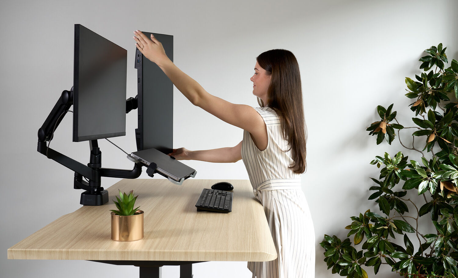 Individual in office using monitor arm addition