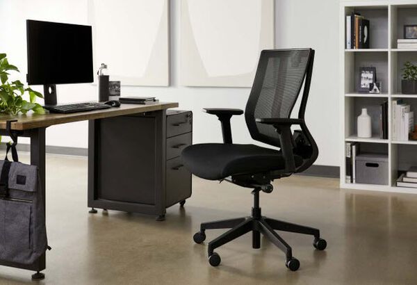 professional seated in a Vari Task Chair at an electric standing desk 