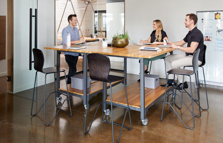 individuals in conference room with vari standing conference table