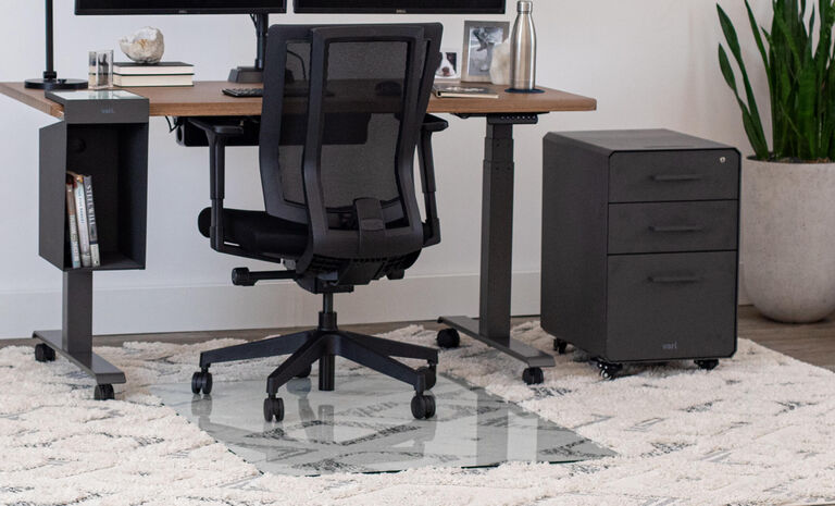 full workstation of vari products with the glass chair mat in use on top of a rug