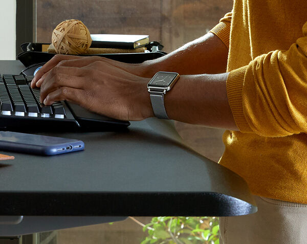 closeup of professional typing while working at a curve electric standing desk 60x30