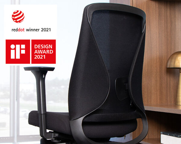 Vari TempurPedic Black ergonomic office chair with mesh backrest and adjustable armrests, placed in a modern office setting near a wooden desk. The chair has won the Red Dot Design Award 2021 and iF Design Award 2021, as indicated by logos in the image.
