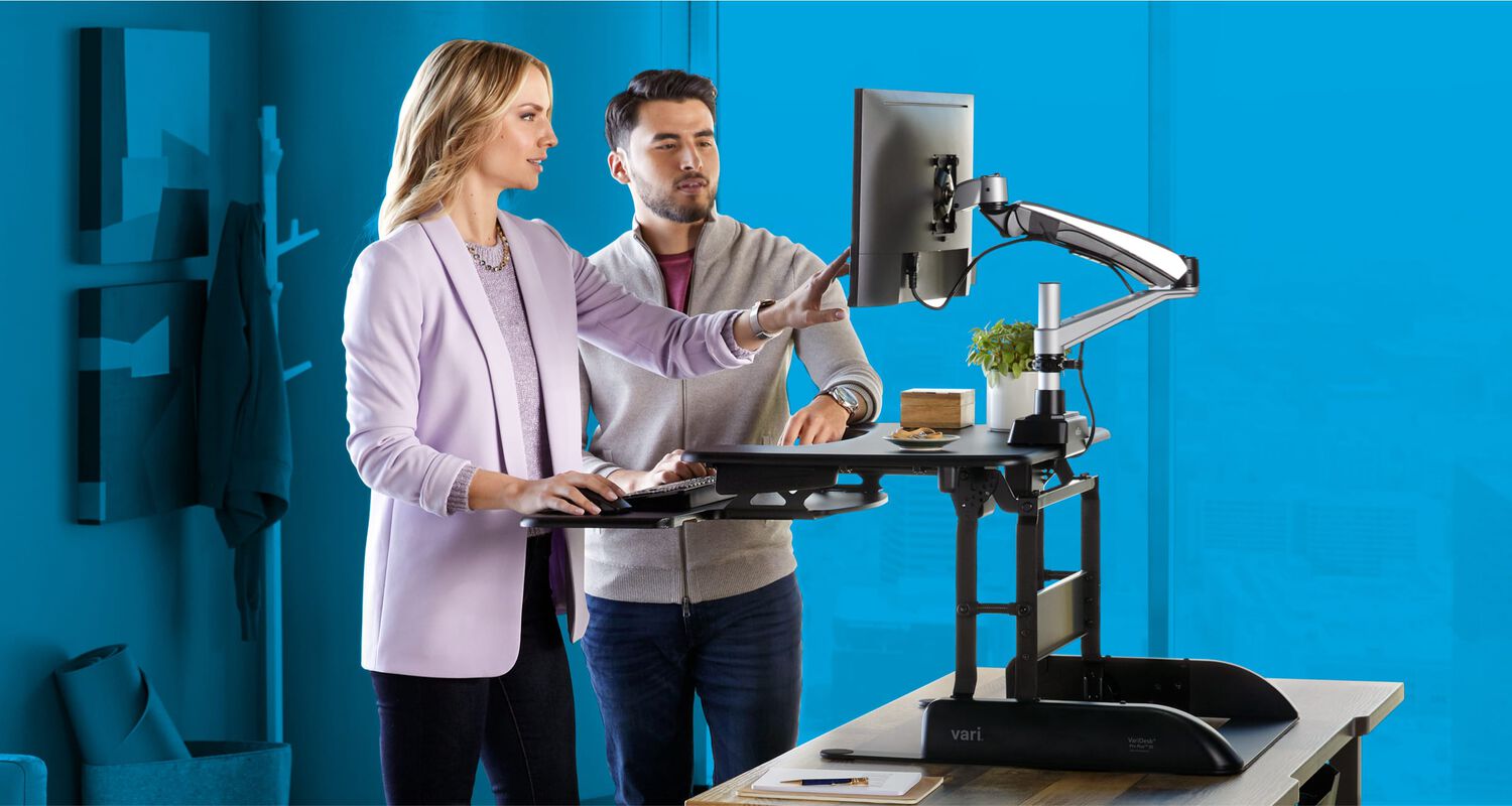 two individuals working side by side in front of a raised converter in an office setting