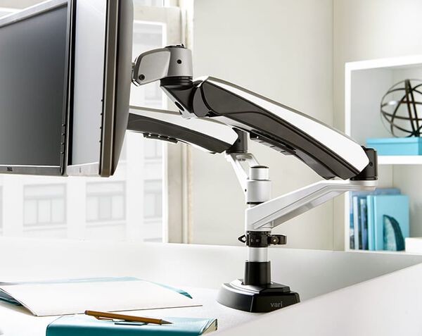 Close up view of monitor arms attached to desk in office