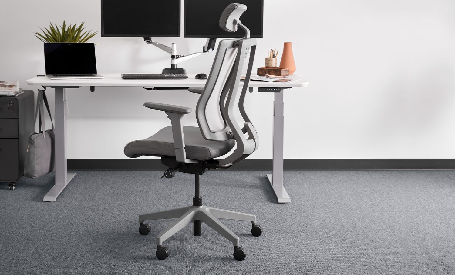 Grey Task Chair with Headrest in front of a desk and workspace.