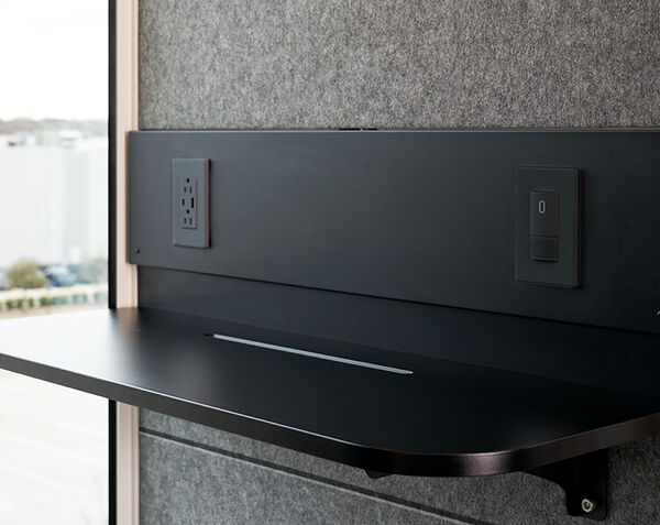 shelf with 2 AC outlets and port USB C inside of privacy booth