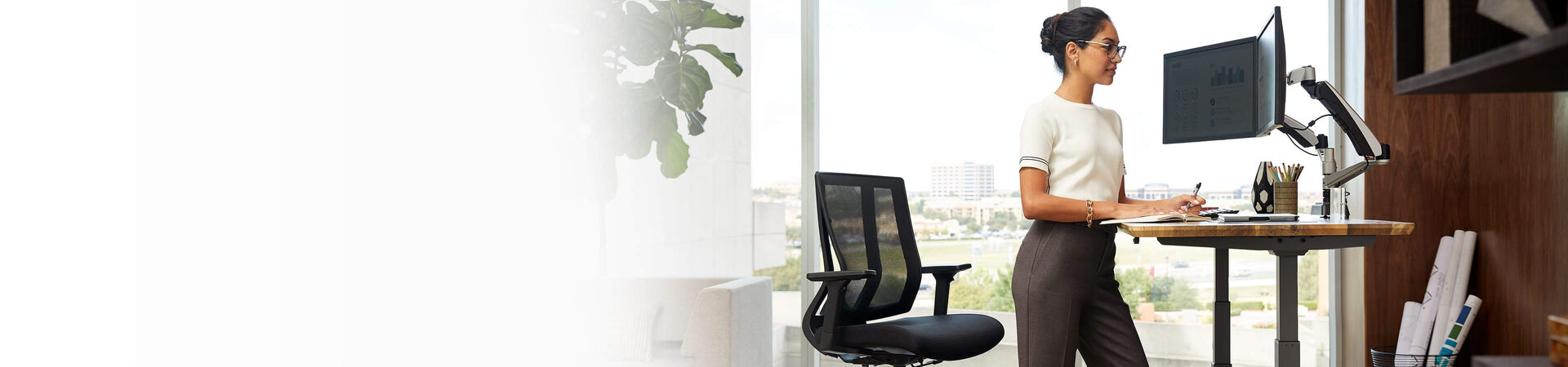 individual working at electric standing desk in raised position