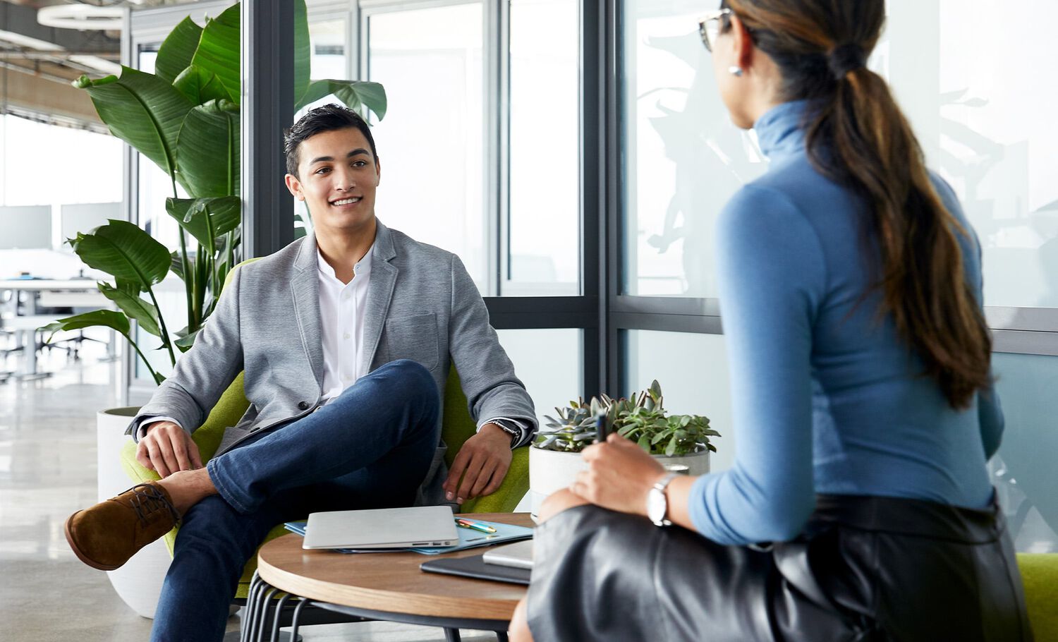 two professionals sitting in chairs at office space