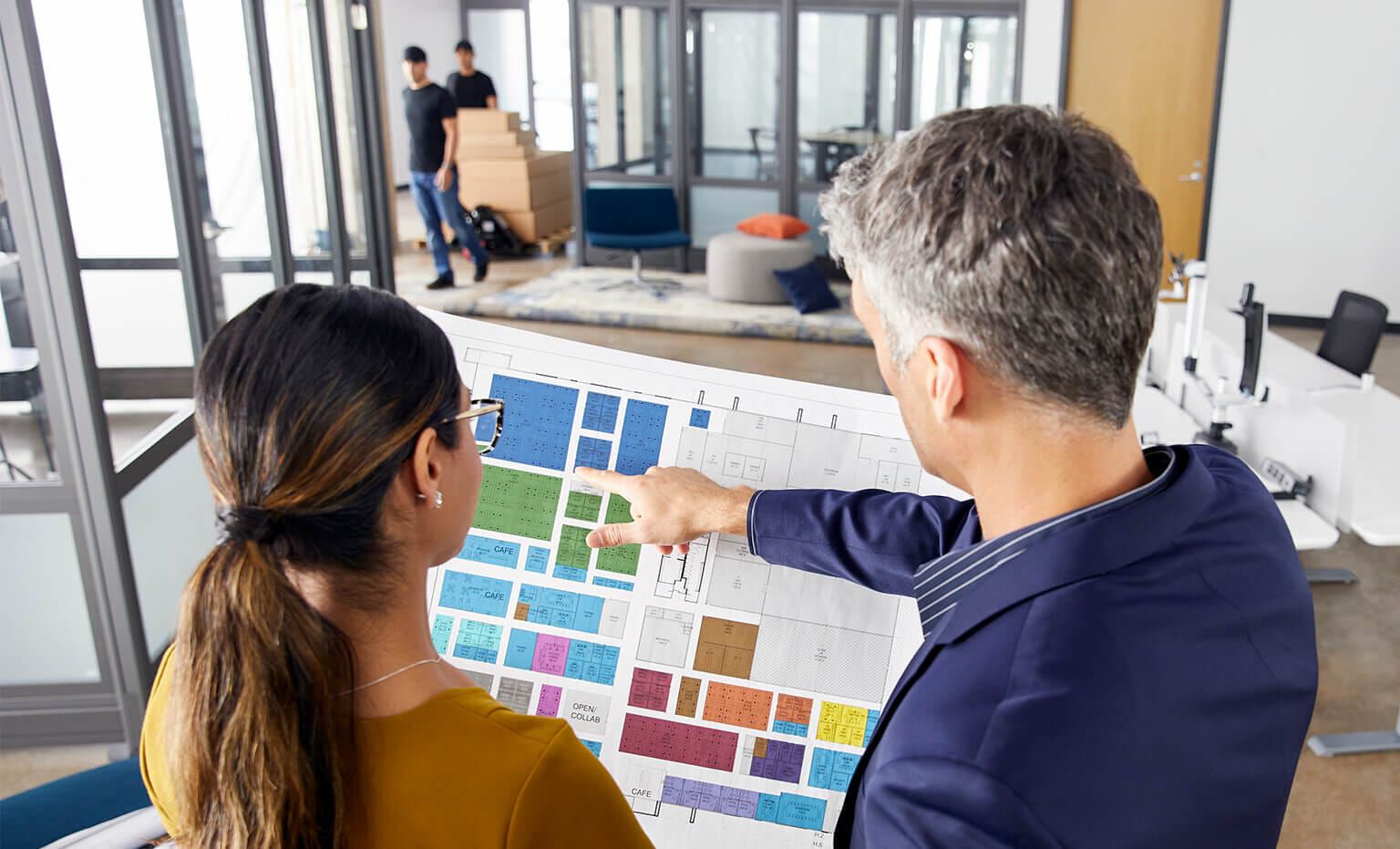 people reviewing a space plan in an office undergoing a furniture design project