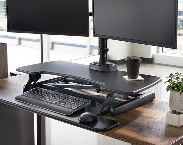 close up view of electric desk converter with office accessories sitting on top of it