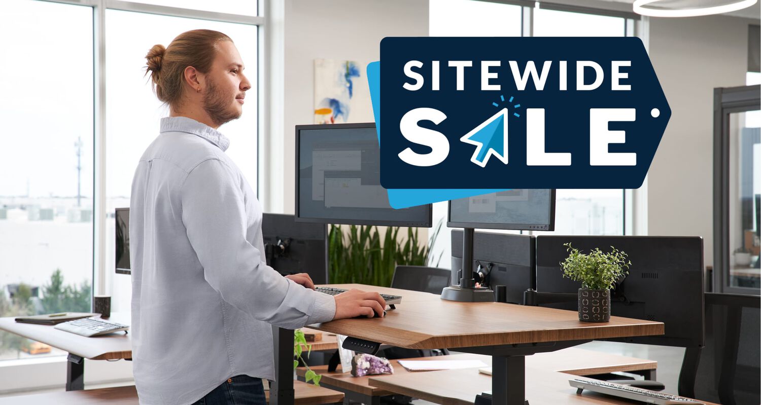 sitewide sale individual working at a electric standing desk in a office setting