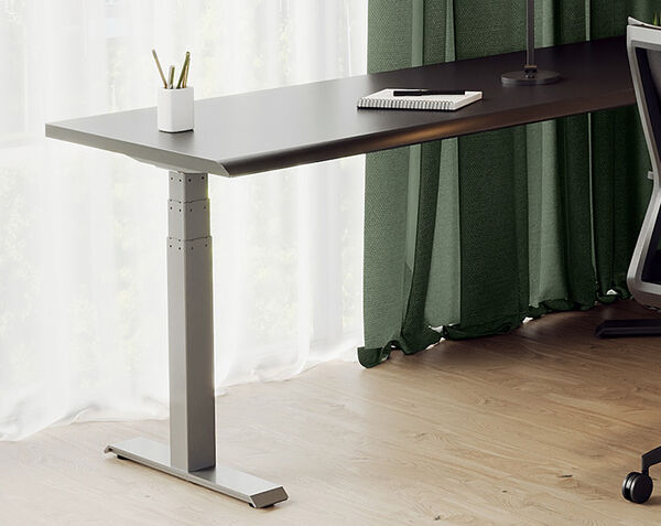 zoomed out view of the l shape electric standing desk next to a desk chair and computer monitors