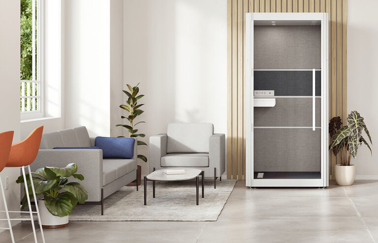 one person privacy booth is against a wall surrounded by couches and lounge chairs