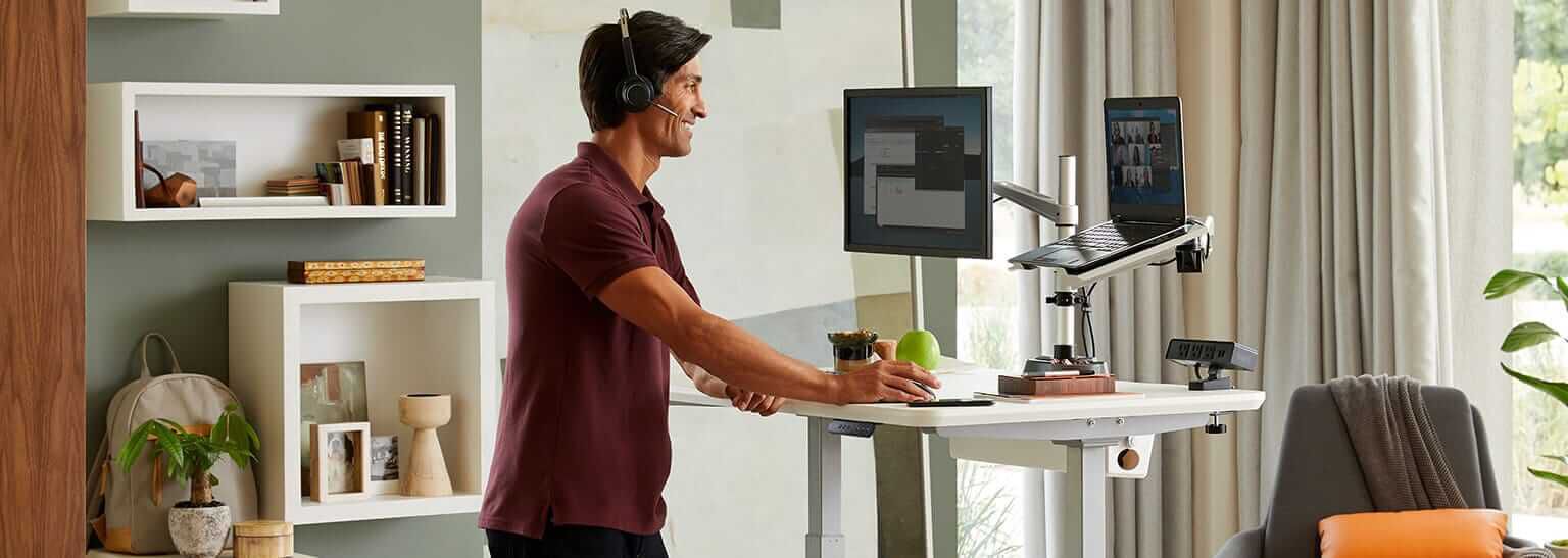 professional working at electric standing desk in home office