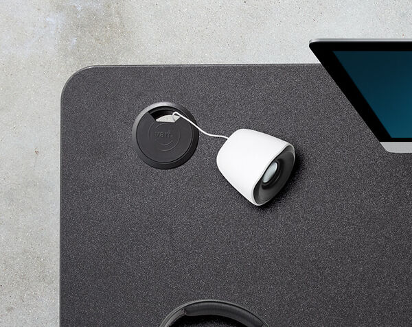 speaker chord being channeled through curve electric standing desk cable grommet