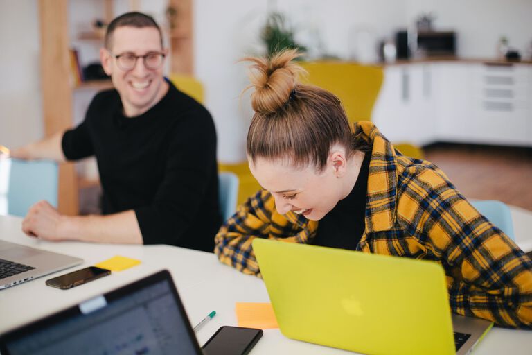 Two professionals working side by side in an office setting.