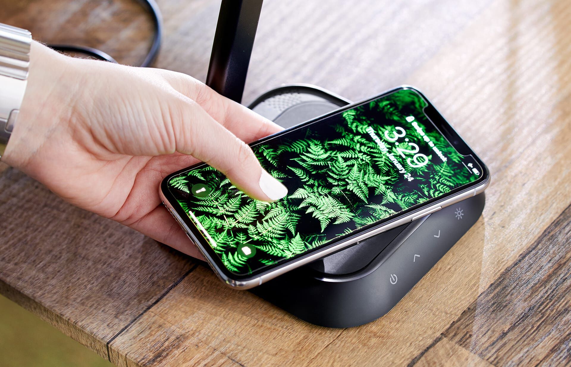 individual placing cell phone on vari LED task lamp and wireless charging