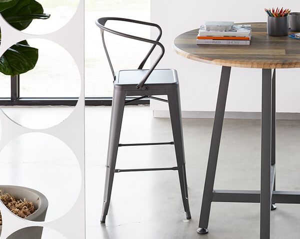 Metal Conference Chair, similar to a barstool, sits next to a standing height table in office setting