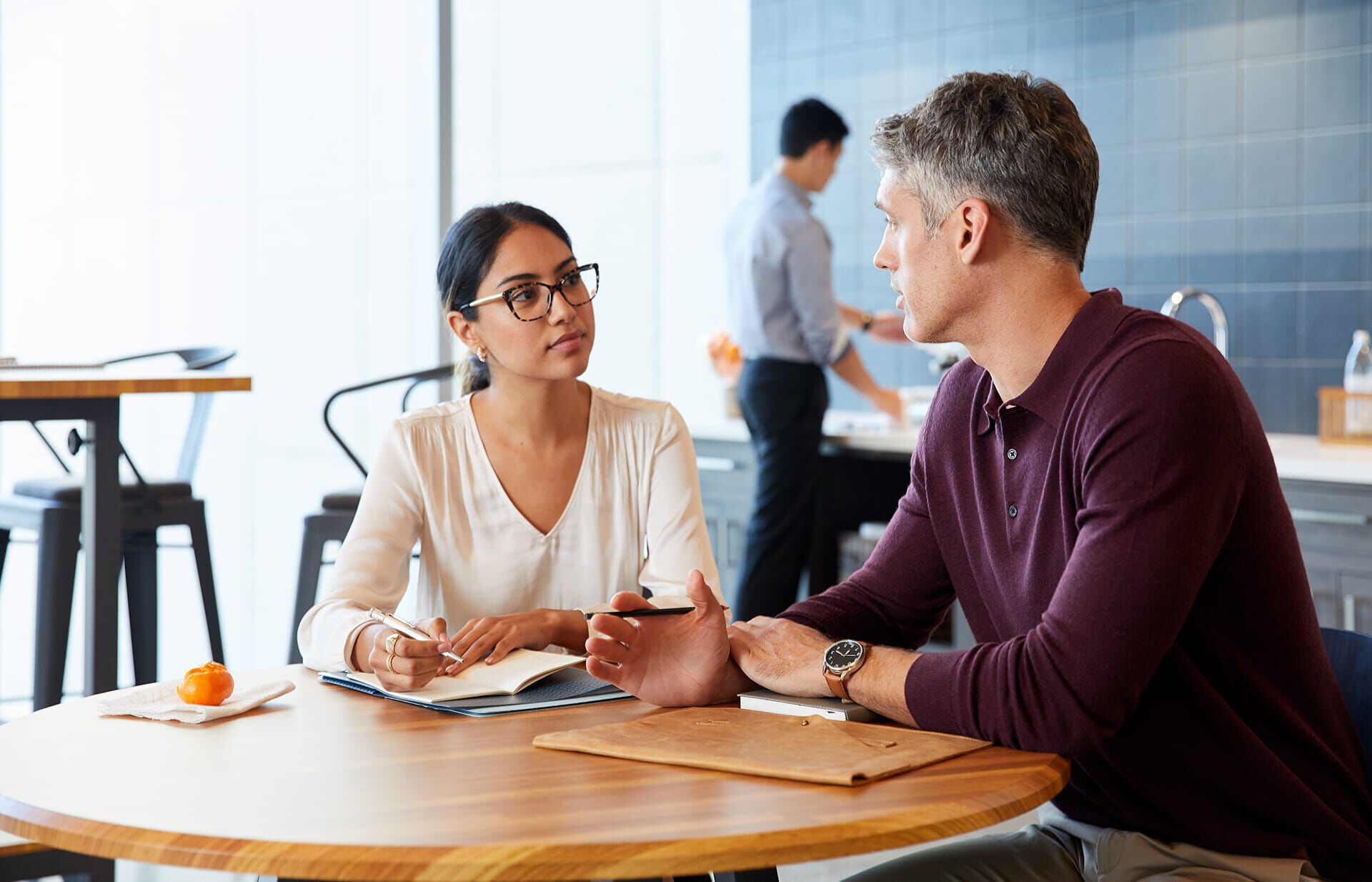 Professionals have casual meeting in breakroom at a round table